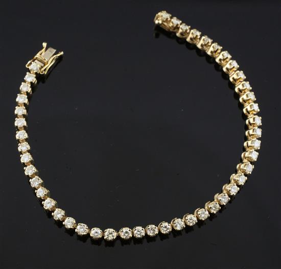 A modern 14ct gold and diamond line bracelet, 7in.